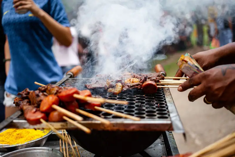Skewers of meat over glowing charcoal