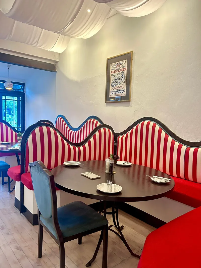 Inside Nostos: red-and-white striped cushions and a vintage poster