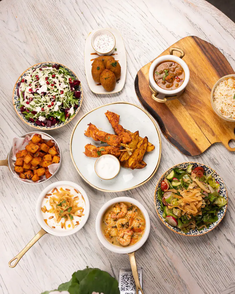 A taverna table seen from above, laid with meze for sharing