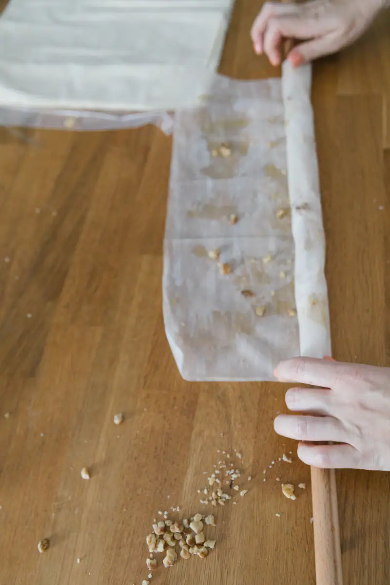 Hands brushing a sheet of filo pastry